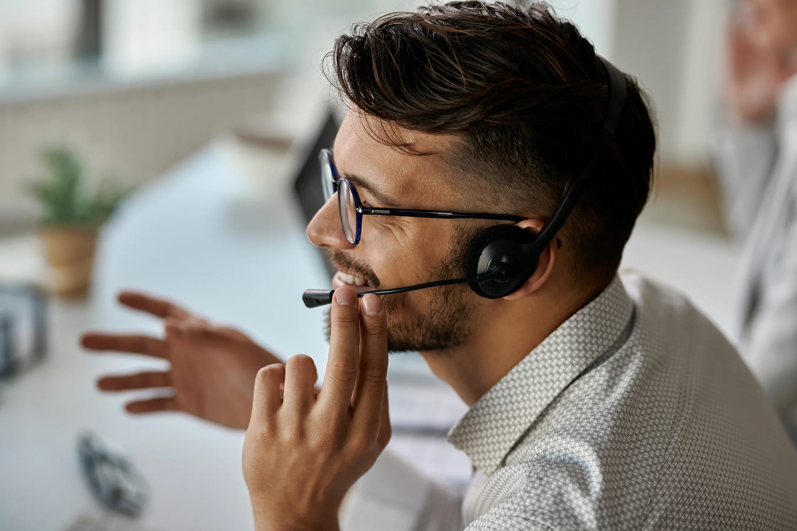 agente de call center feliz usando fone de ouvido enquanto conversa com clientes e trabalha no escritorio e1756556837974